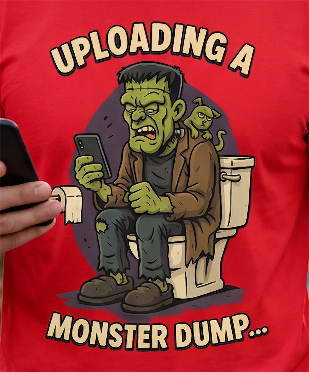 Close-up of Monster Dump graphic on red Halloween shirt featuring green monster, toilet and cat