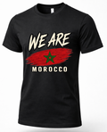 A black short-sleeve crewneck t-shirt featuring a distressed graphic print of the Moroccan flag and the text 'WE ARE MOROCCO' in white, displayed on a clean white background.