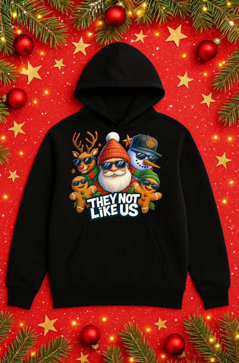 Black Christmas hoodie featuring a funny holiday streetwear graphic with Santa, reindeer, snowman, and gingerbread characters wearing sunglasses, with “They Not Like Us” text on a festive red Christmas background.