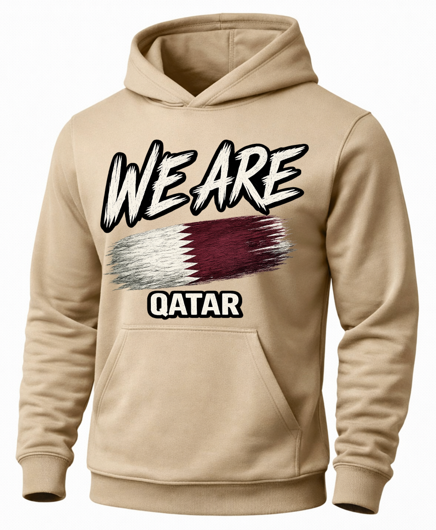A beige pullover hoodie with a graphic print on the front. The design features the text 'WE ARE' in a white and black brush-stroke style above a stylized Qatar flag, and 'QATAR' in white block letters below.