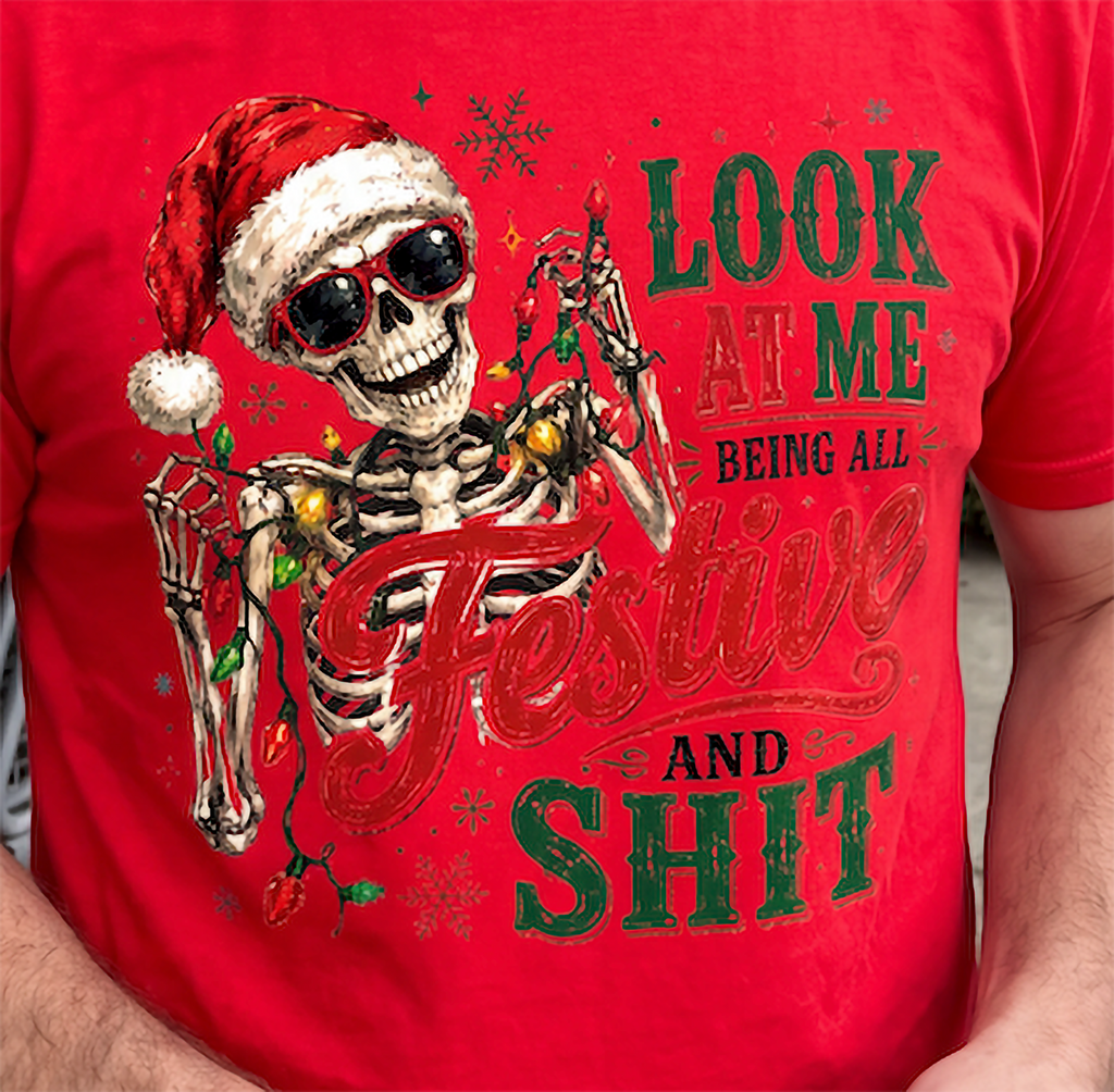 Red close-up: Close-up of festive Santa skeleton and Christmas lights graphic on red holiday shirt.