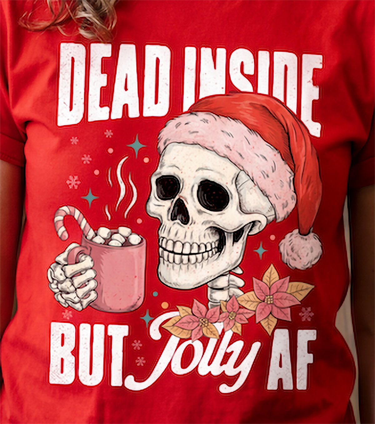 Close-up of Dead Inside But Jolly AF skeleton Christmas graphic printed on red shirt.