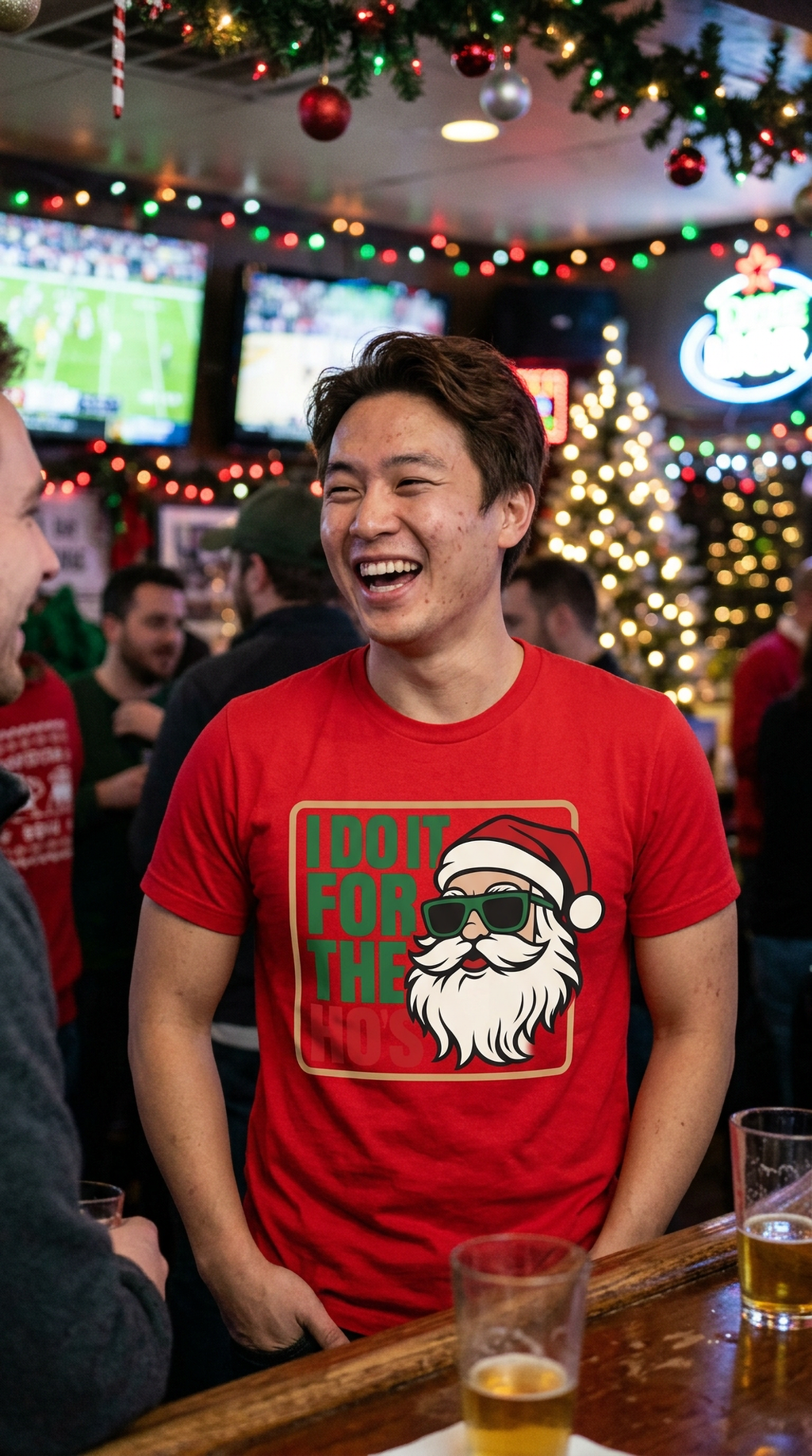 Smiling man wearing a red funny Santa Christmas t-shirt at a festive holiday party.