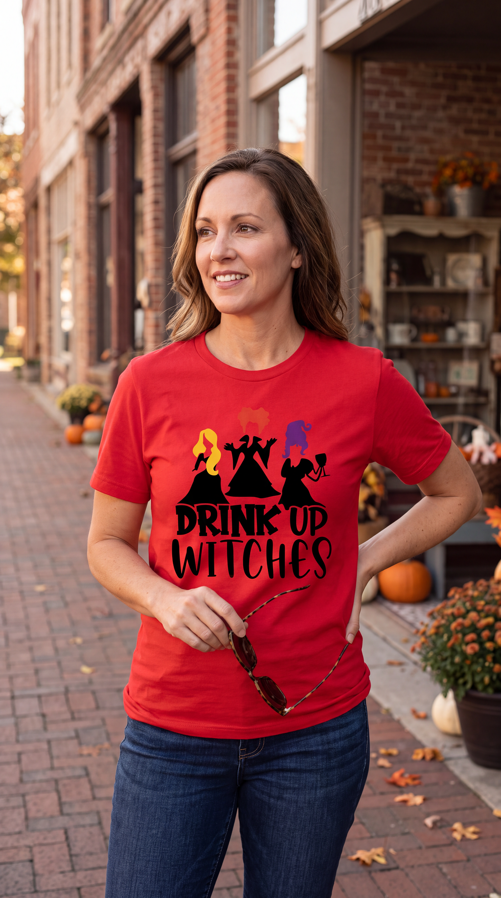 Woman wearing red Drink Up Witches Hocus Pocus Halloween graphic tee