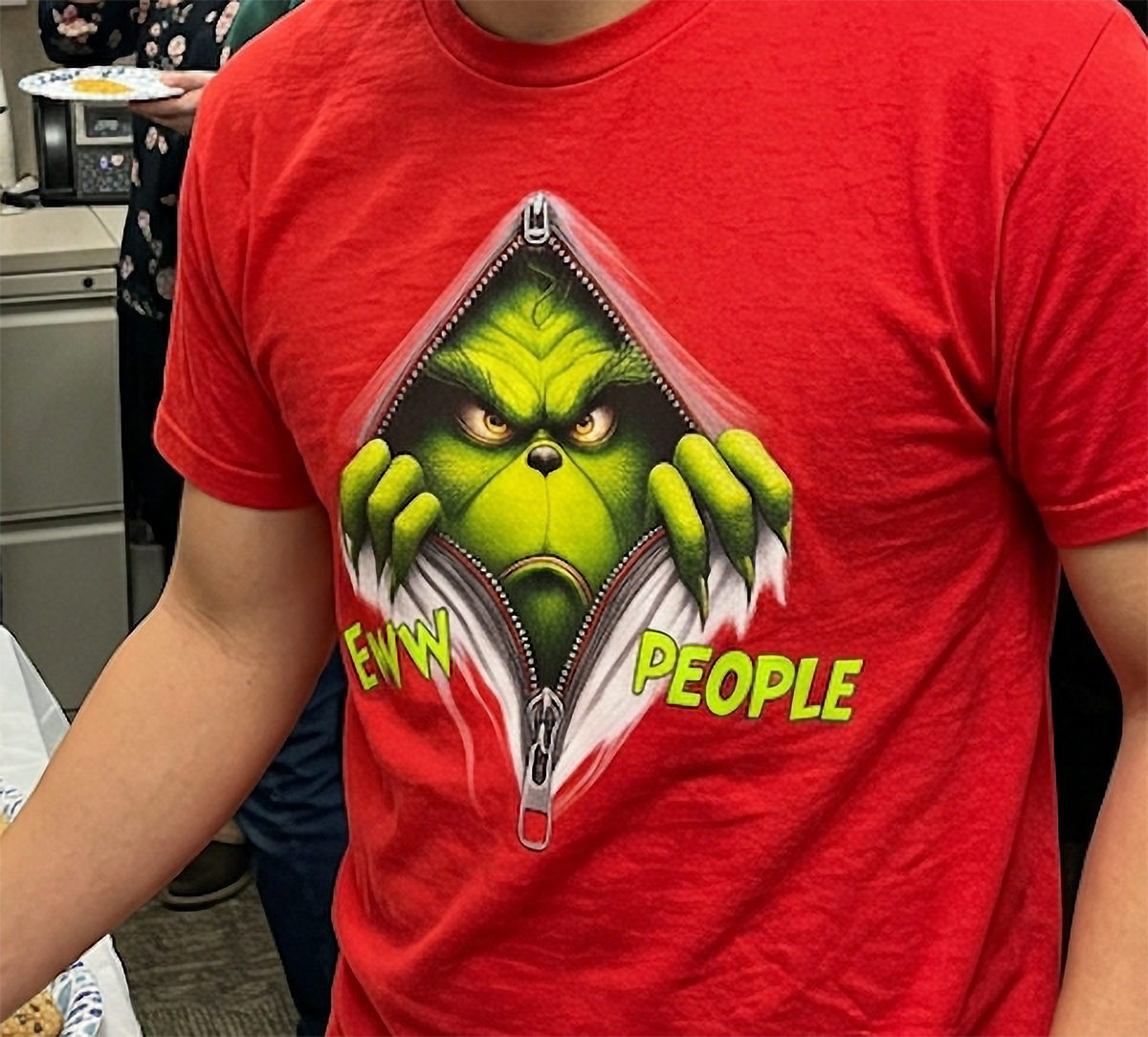 Red Close-Up: Close-up of the bright green Eww People Grinch Christmas graphic printed on a red shirt.