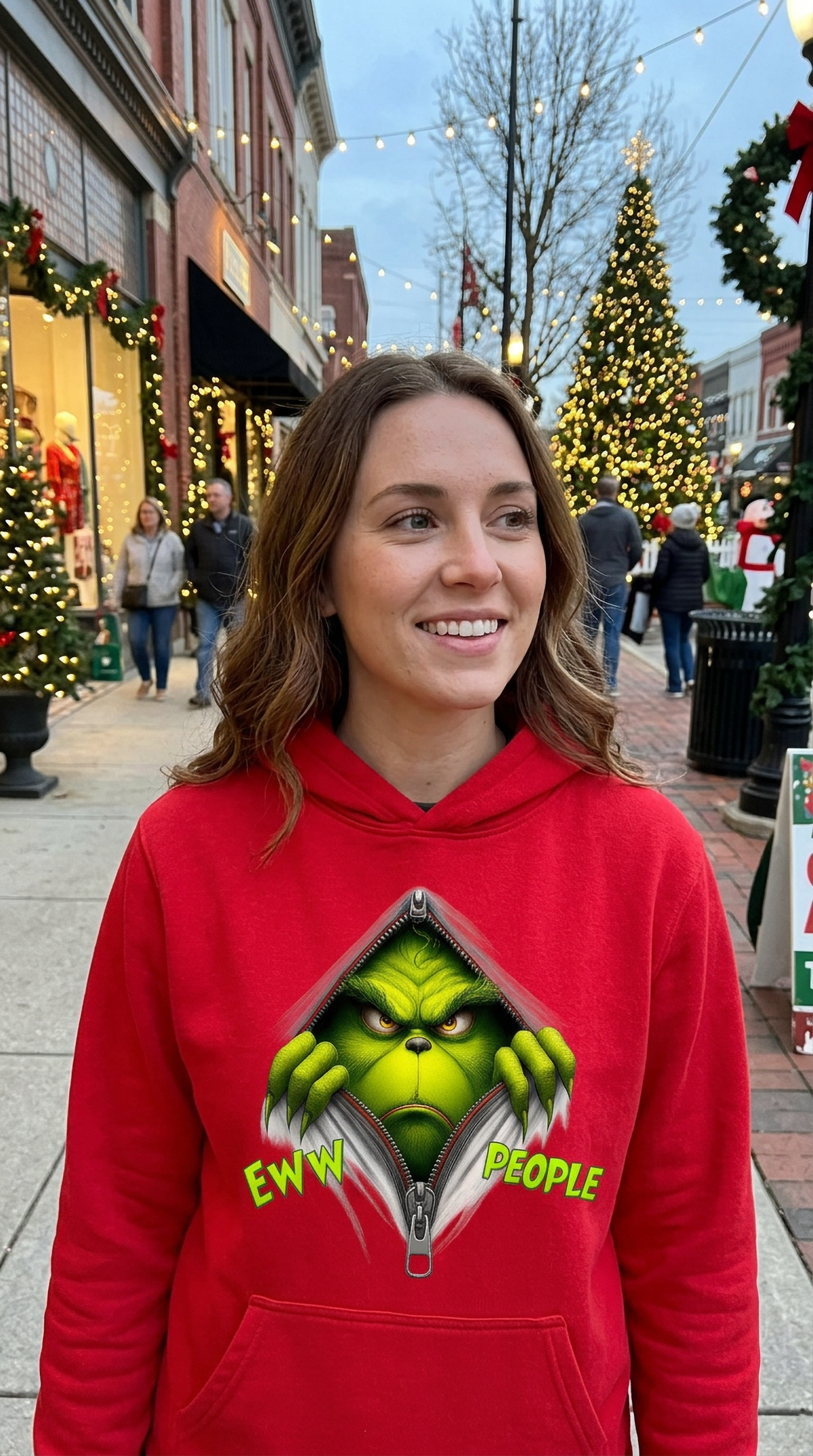 Woman wearing red Eww People Grinch Christmas hoodie at a festive holiday market