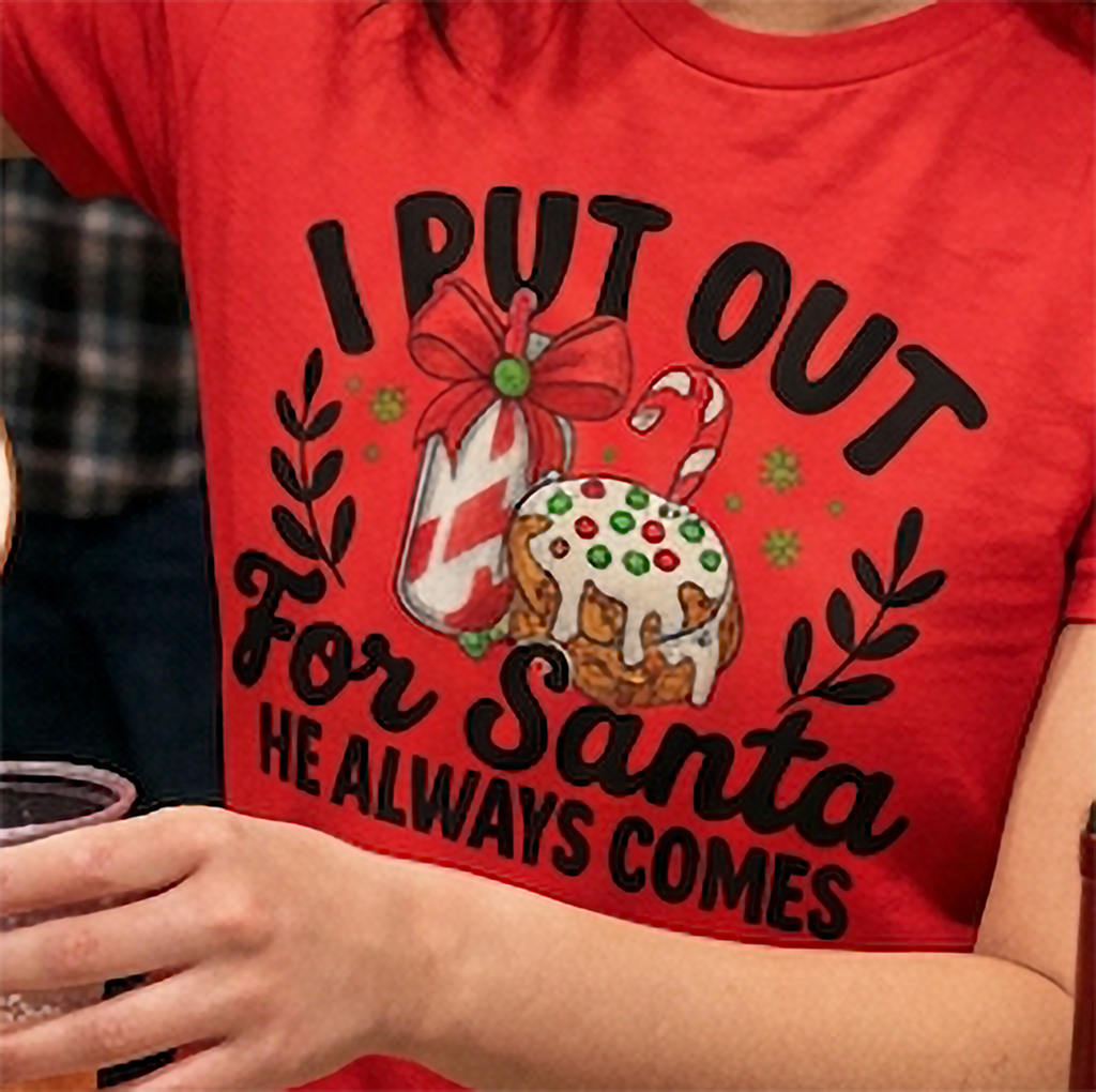 Close-up of I Put Out for Santa He Always Comes graphic on red Christmas shirt