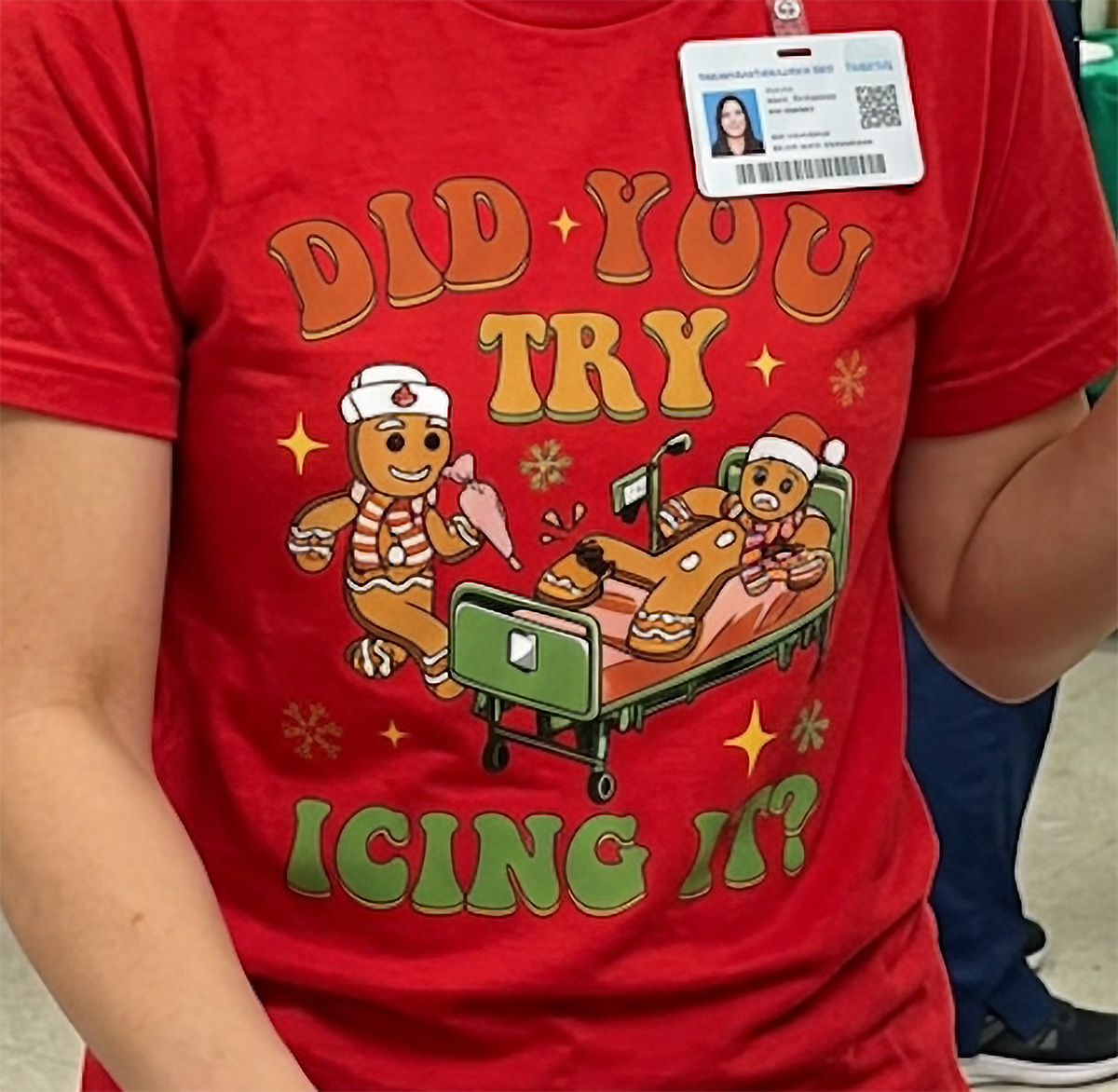 Close-up of festive gingerbread medical humor graphic on a red Christmas t-shirt.