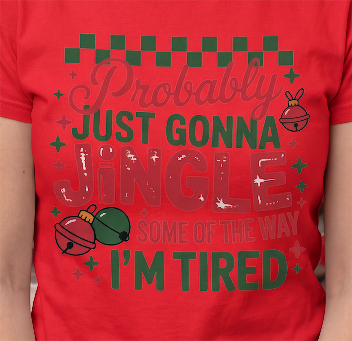 Close-up of Probably Just Gonna Jingle Some of the Way I’m Tired Christmas design printed on a red T-shirt.
