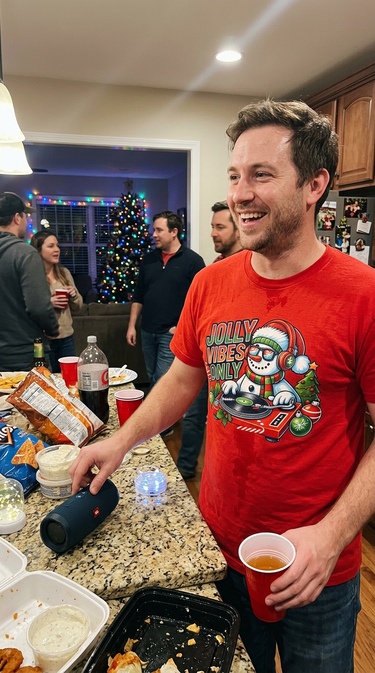 Red Lifestyle: Man wearing a red Jolly Vibes Only Christmas t-shirt at a festive gathering.