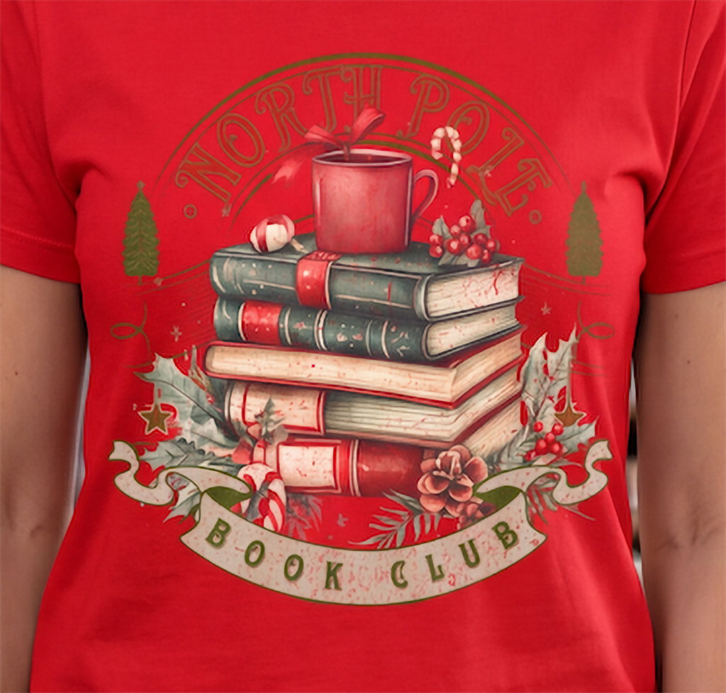 Close-up of North Pole Book Club Christmas graphic on red shirt featuring stacked books and vintage holiday artwork.