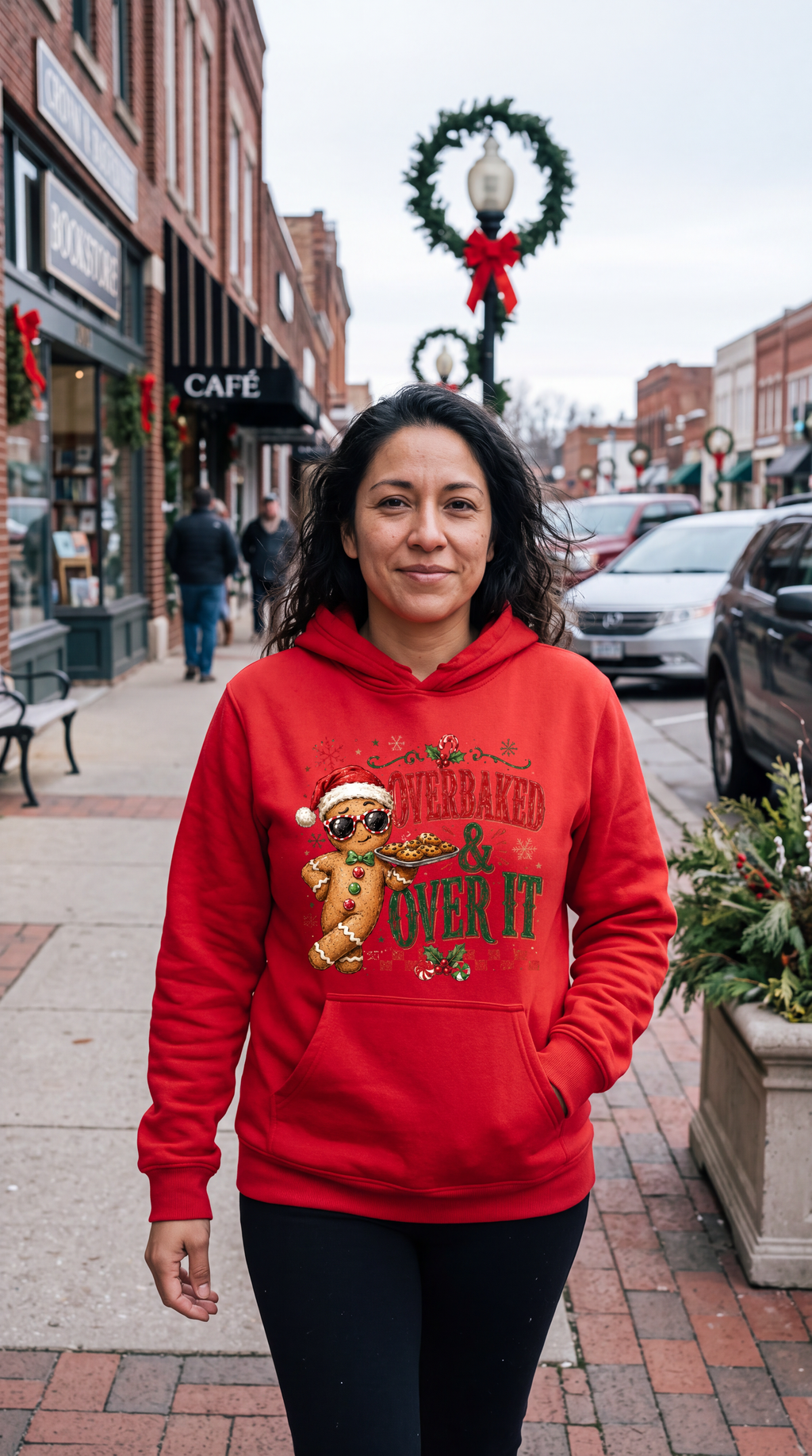 Woman wearing red funny gingerbread Christmas hoodie with Overbaked and Over It design