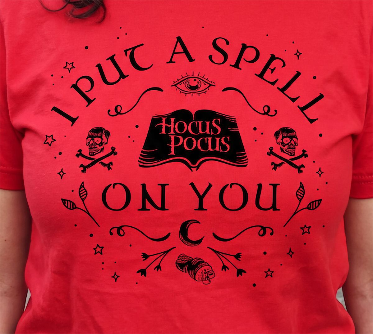 Close-up of red Hocus Pocus Halloween shirt with witchy spellbook design
