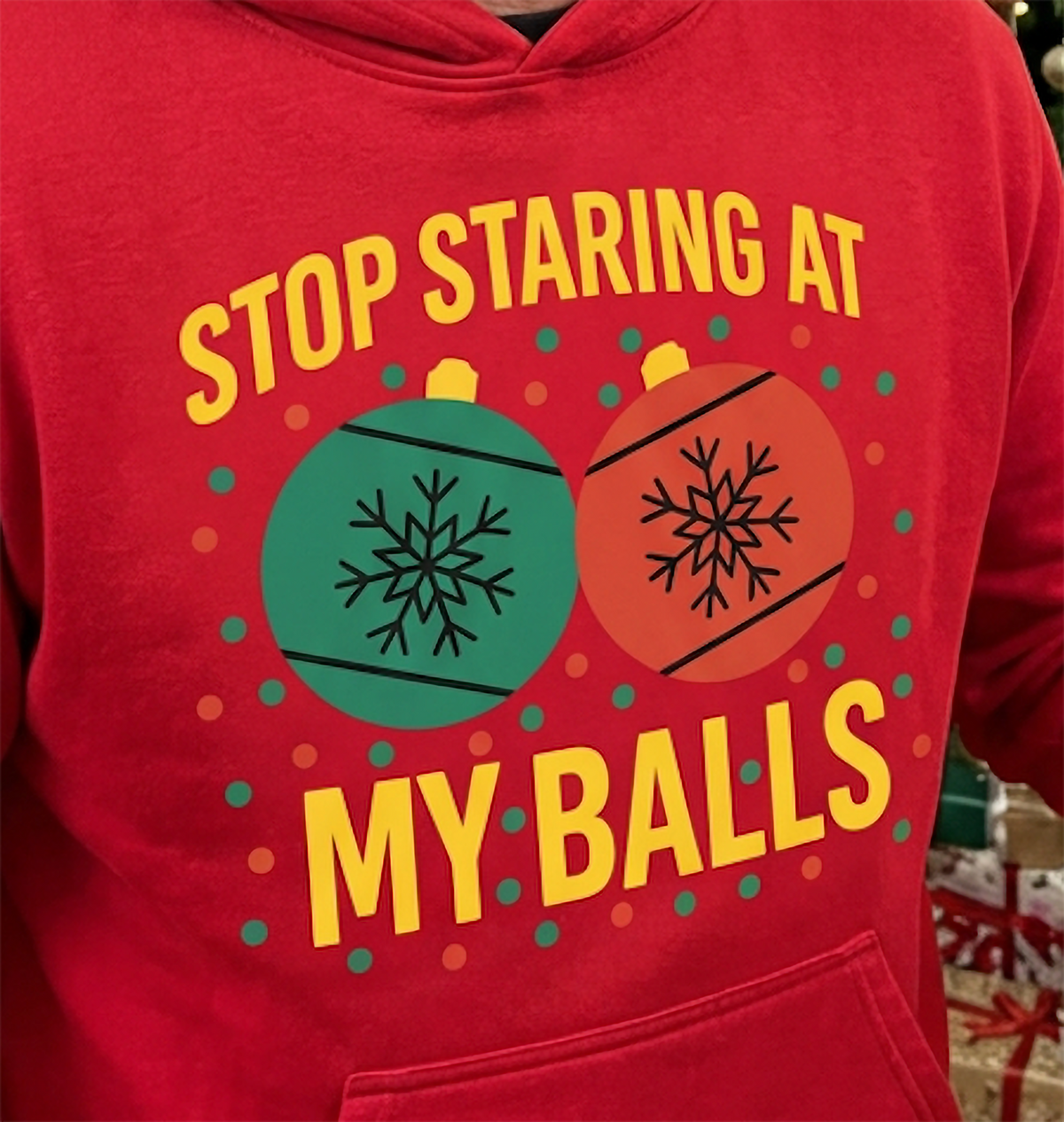 Close-up of Stop Staring at My Balls ornament graphic on red Christmas hoodie