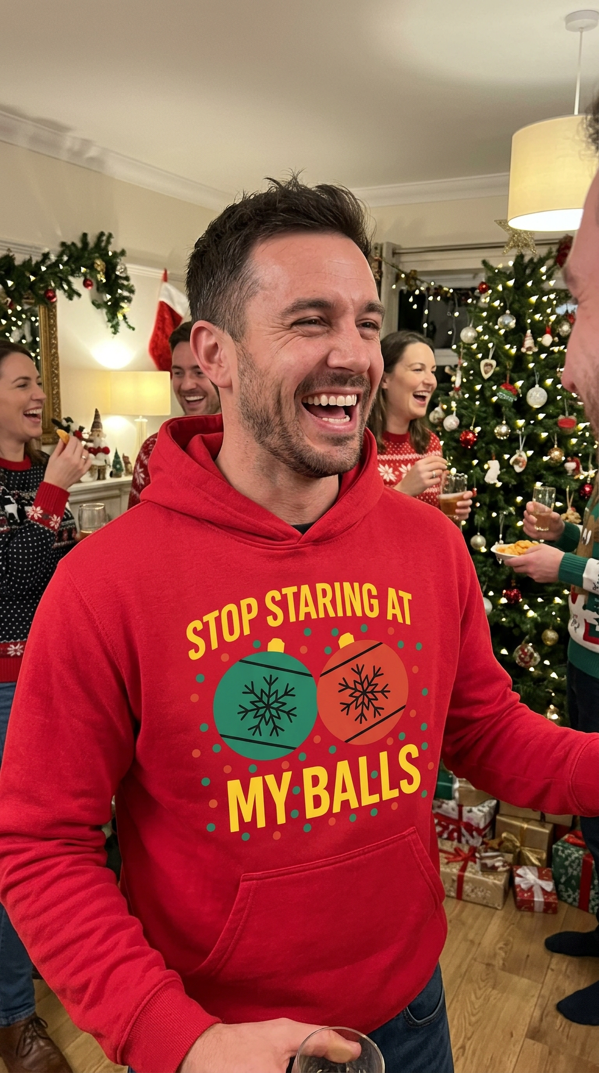 Man wearing red Stop Staring at My Balls Christmas hoodie at a festive holiday party