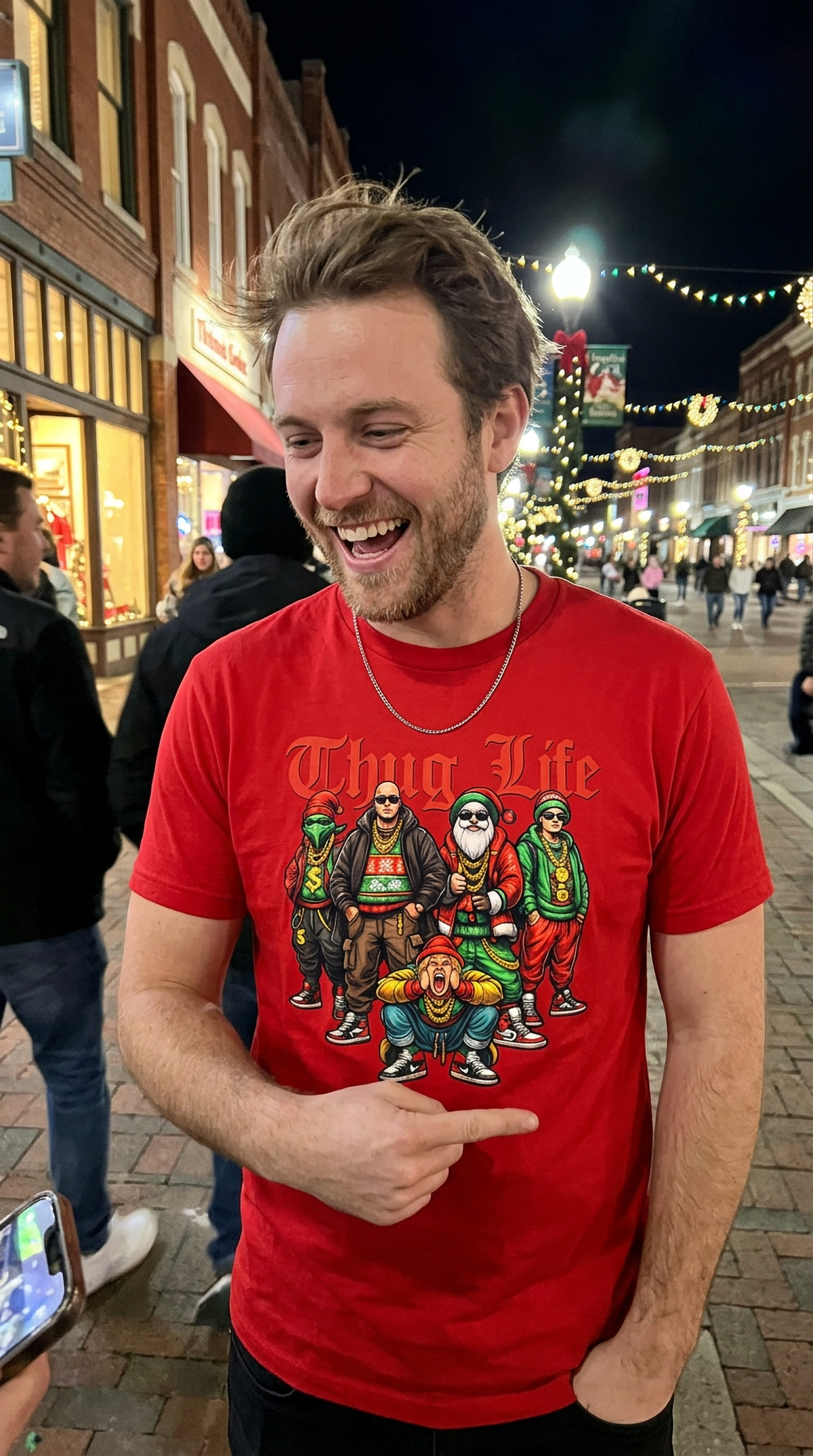 Man wearing red Thug Life Christmas graphic t-shirt at a festive outdoor evening gathering