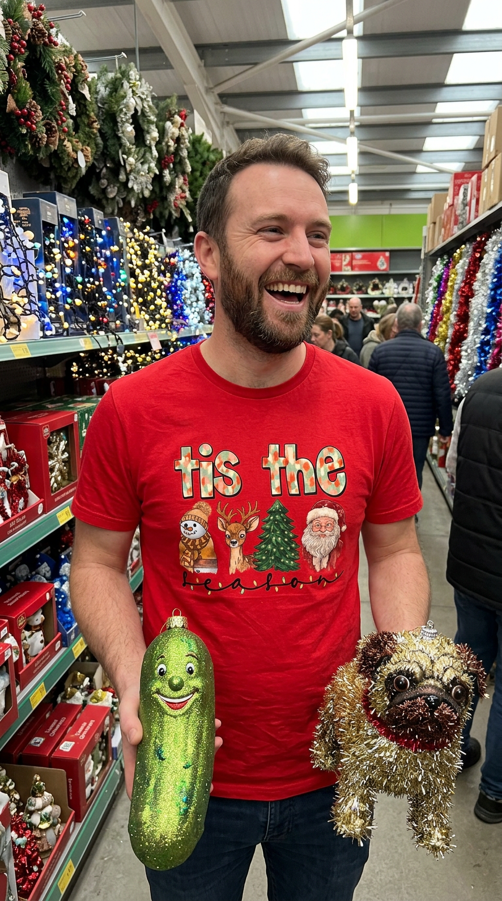 Man wearing red Tis the Season Christmas graphic shirt while shopping in a store filled with holiday decorations and festive merchandise.
