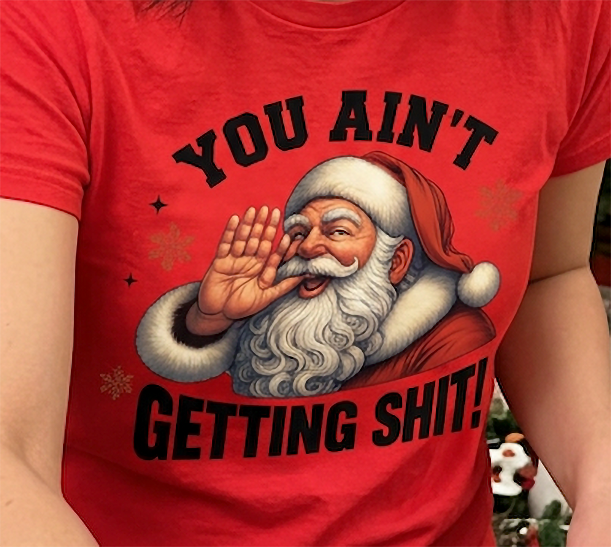 Red Close-Up: Close-up of You Ain't Getting Shit Christmas artwork featuring Santa Claus and festive snowflakes printed on red fabric.