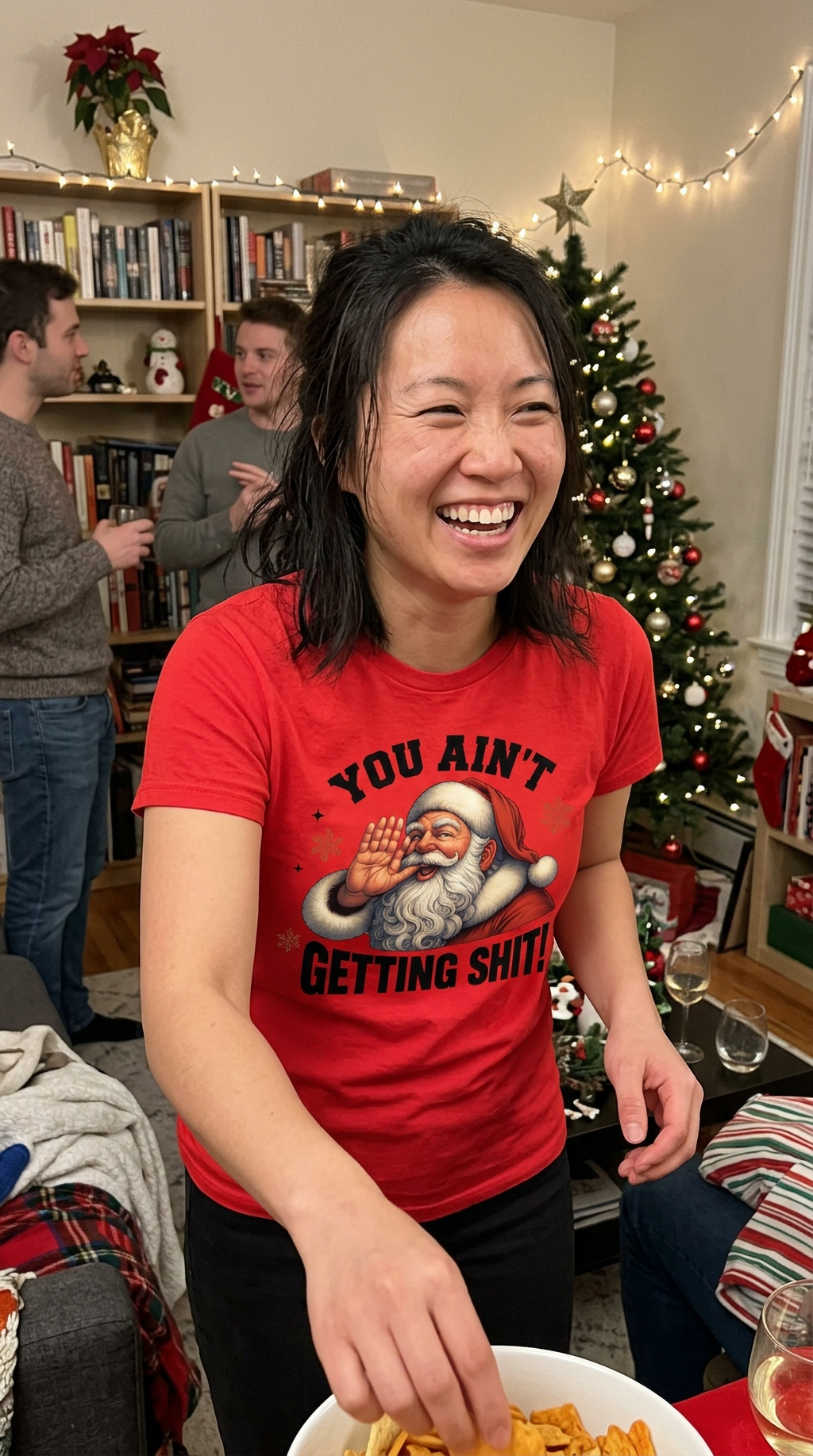 Red Lifestyle: Woman wearing a red You Ain't Getting Shit Christmas graphic t-shirt at a festive holiday gathering.