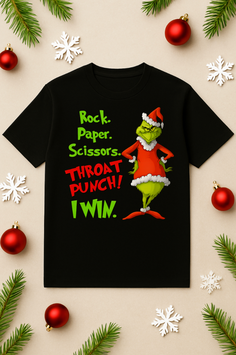 Black Christmas t-shirt featuring a green mischievous character in a red Santa outfit with the phrase “Rock. Paper. Scissors. Throat Punch! I Win.” displayed flat on a beige background with ornaments, snowflakes, and pine branches.