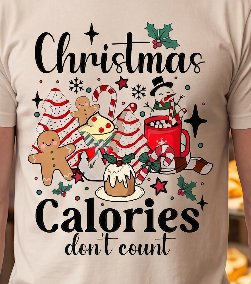Close-up of sand Christmas Calories Don’t Count shirt featuring colorful Christmas food graphics