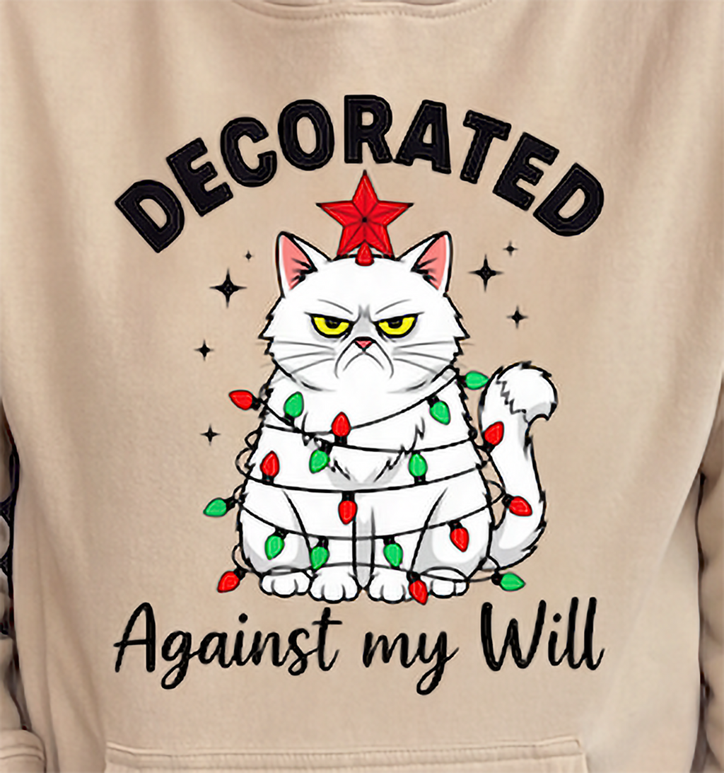 Close-up of sand Decorated Against My Will Christmas cat hoodie graphic