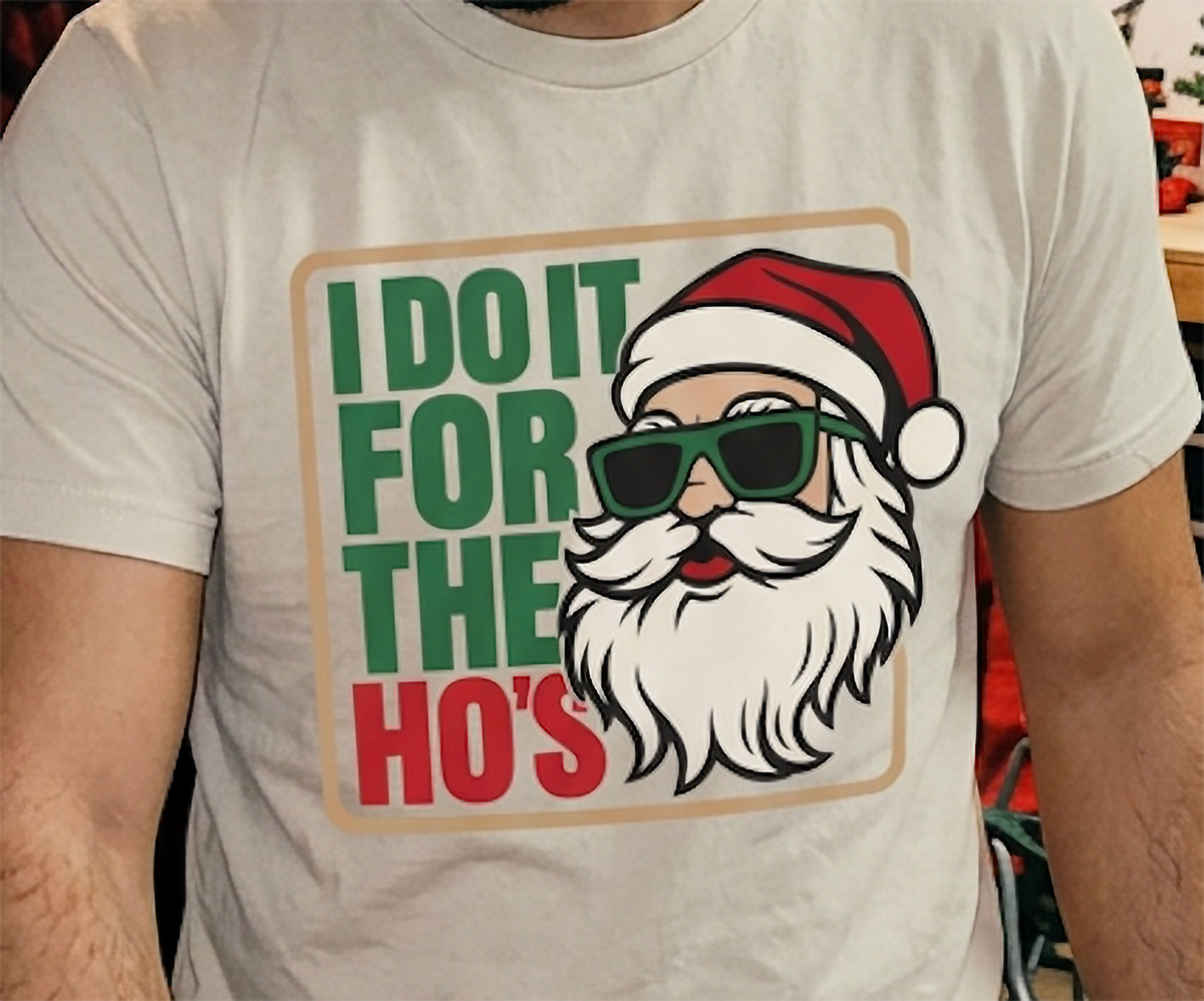 Close-up of I Do It for the Ho's funny Christmas graphic on a sand-colored unisex t-shirt.