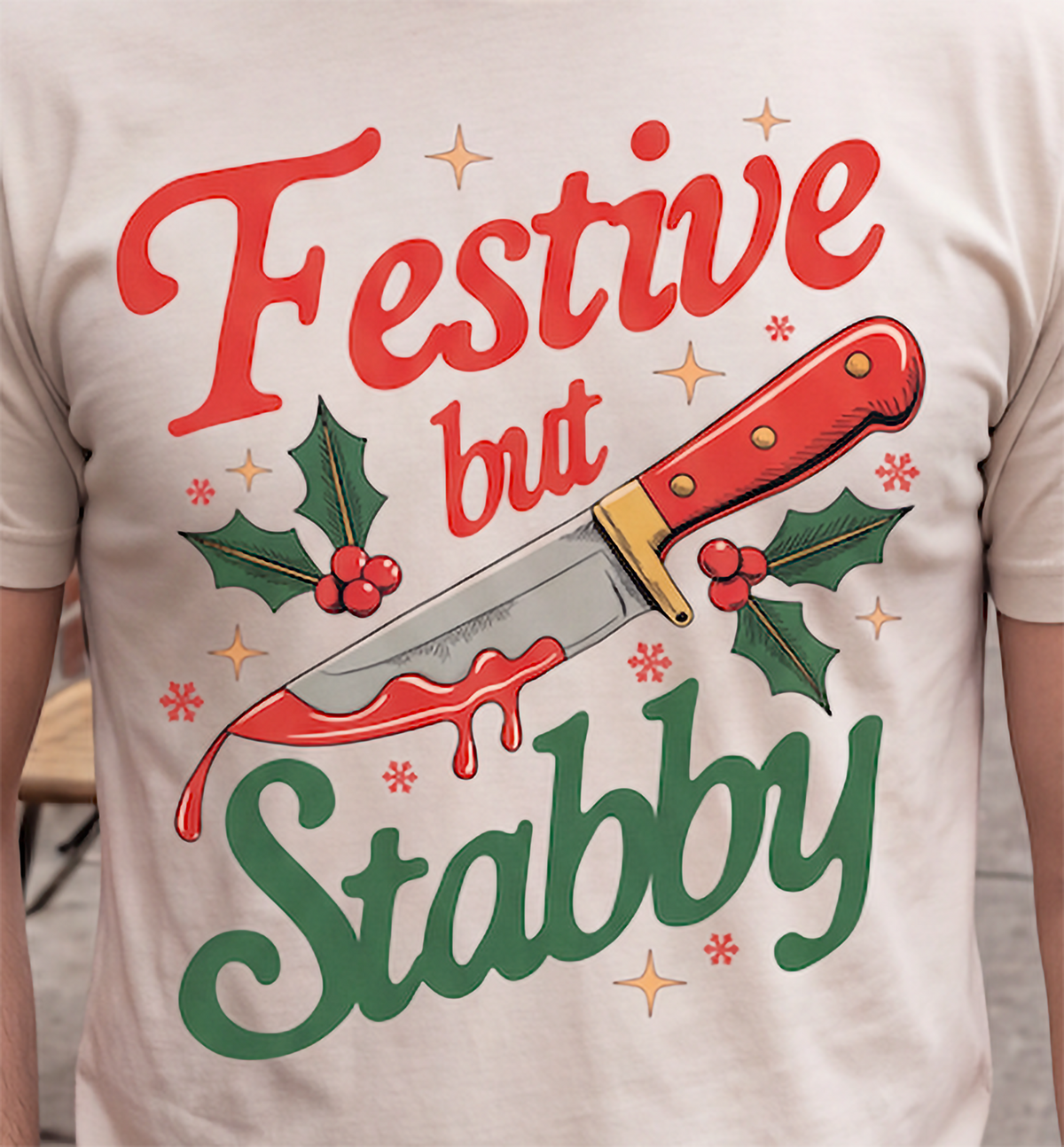 Close-up of Festive But Stabby holiday knife design on sand shirt