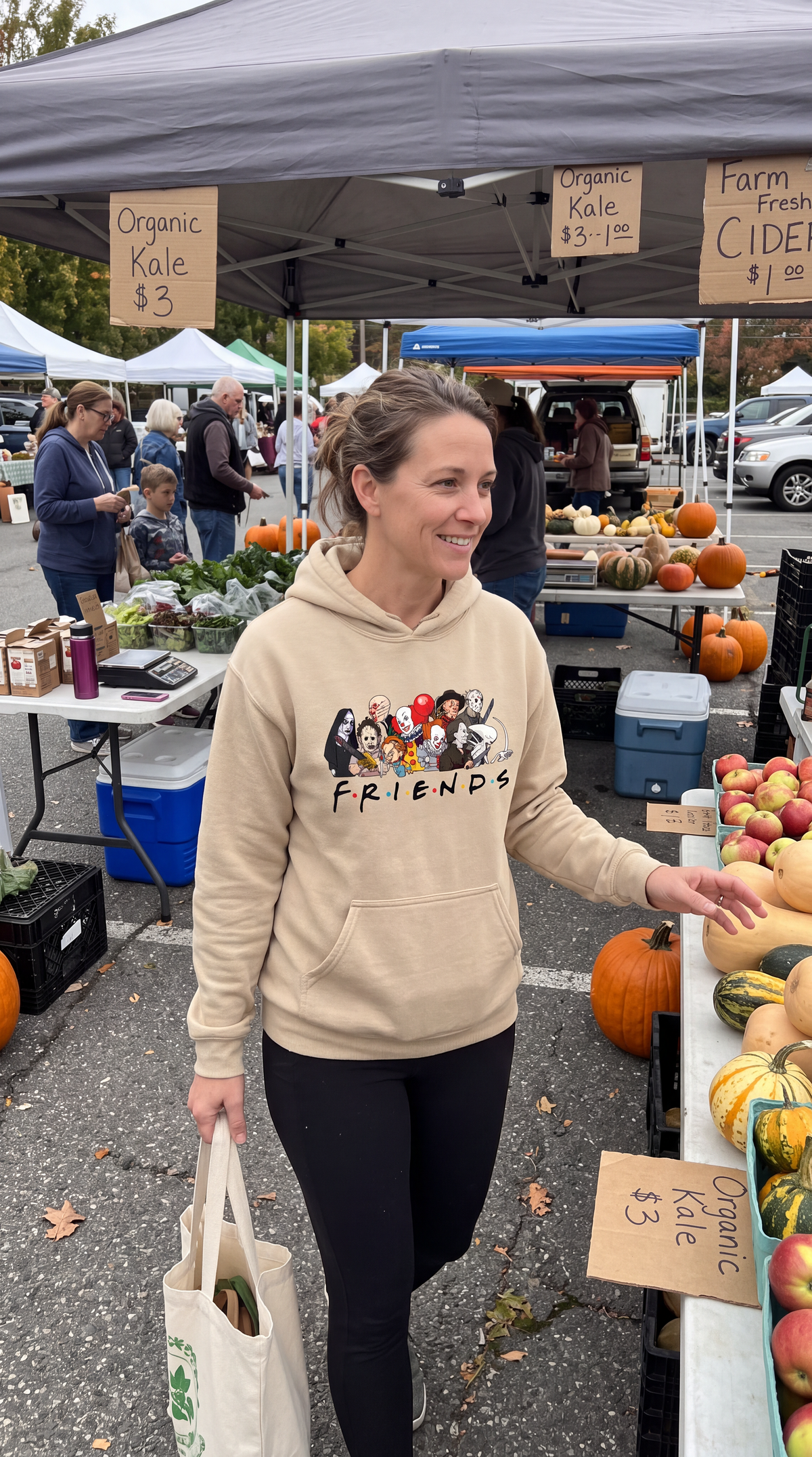 Woman wearing sand Horror Friends hoodie with classic scary movie characters