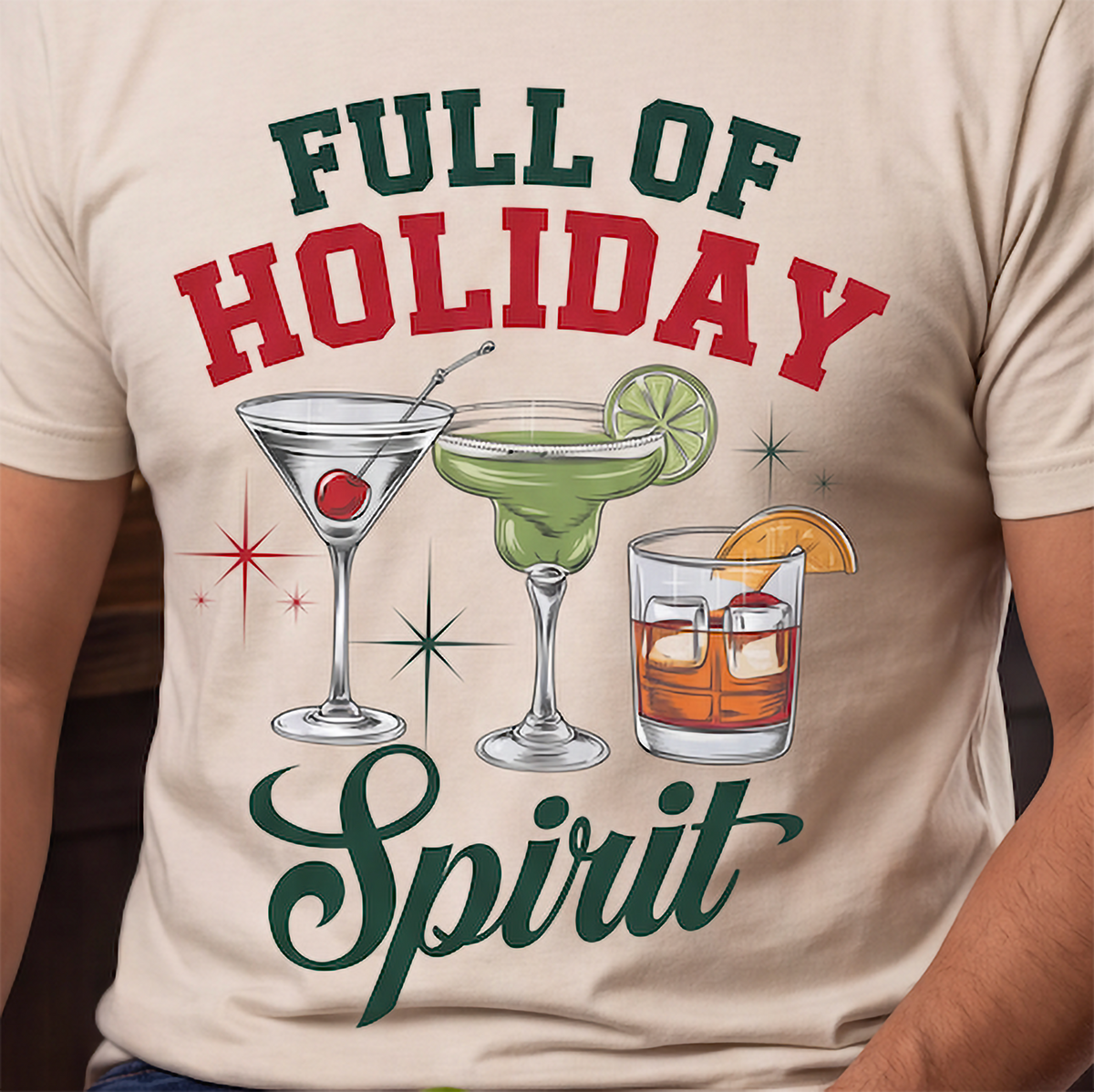 Close-up of Full of Holiday Spirit cocktail Christmas design on sand shirt.