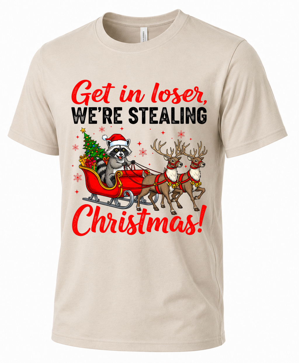 Sand Christmas graphic tee featuring a raccoon riding Santa’s sleigh with two reindeer.