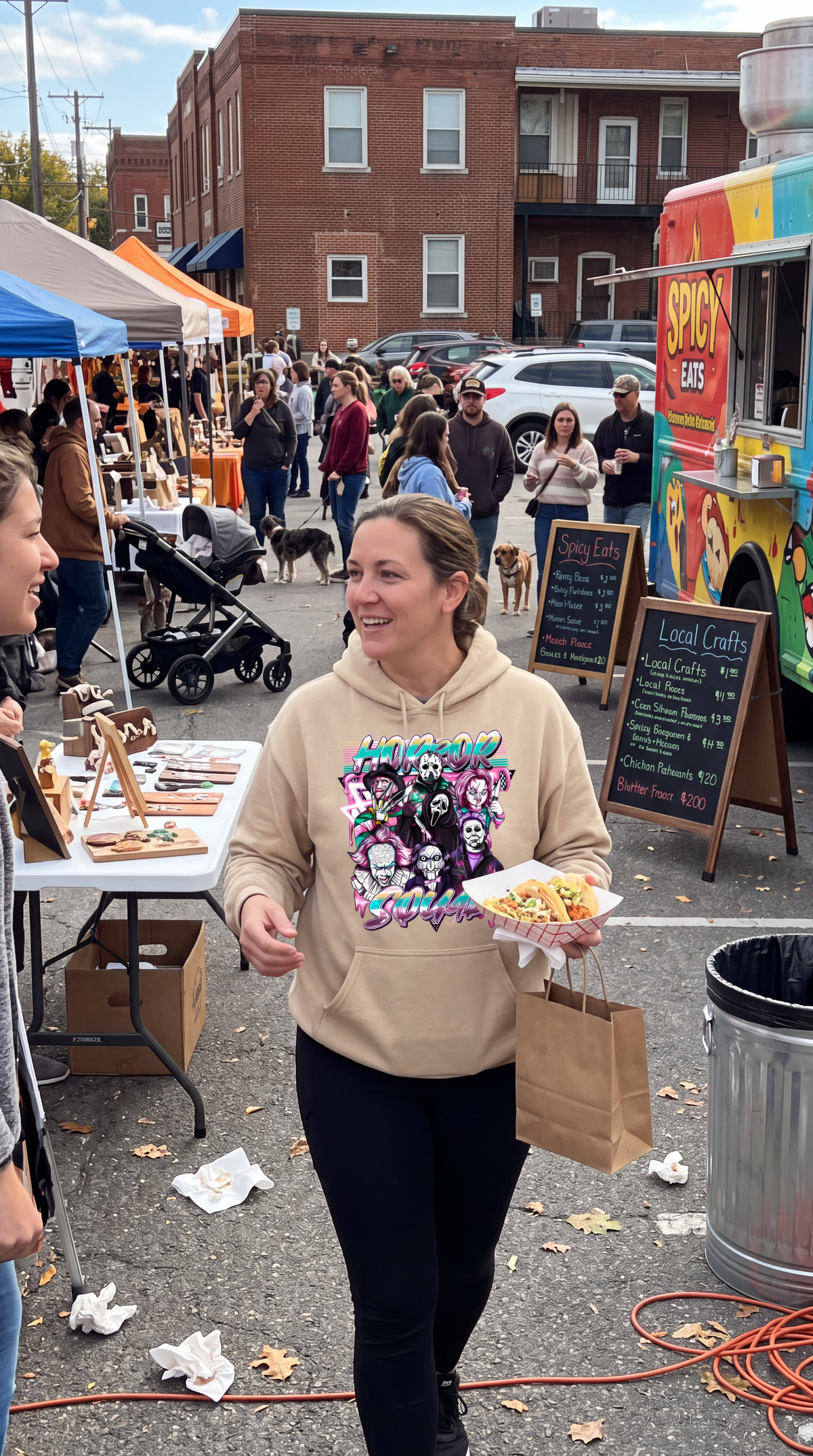 Woman wearing sand Horror Squad hoodie with classic horror movie characters