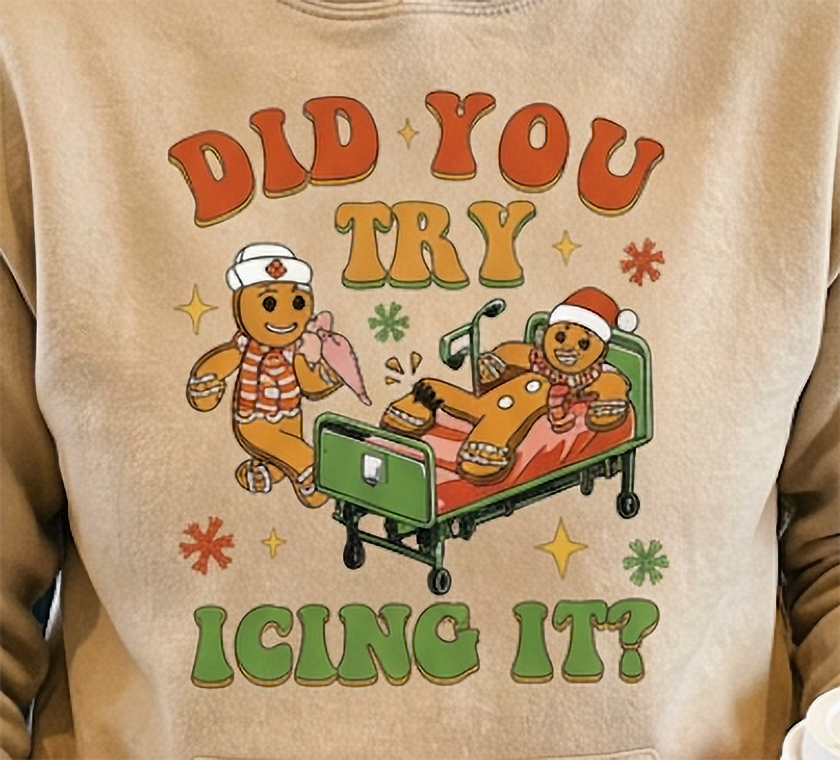 Close-up of Did You Try Icing It gingerbread graphic on sand Christmas hoodie