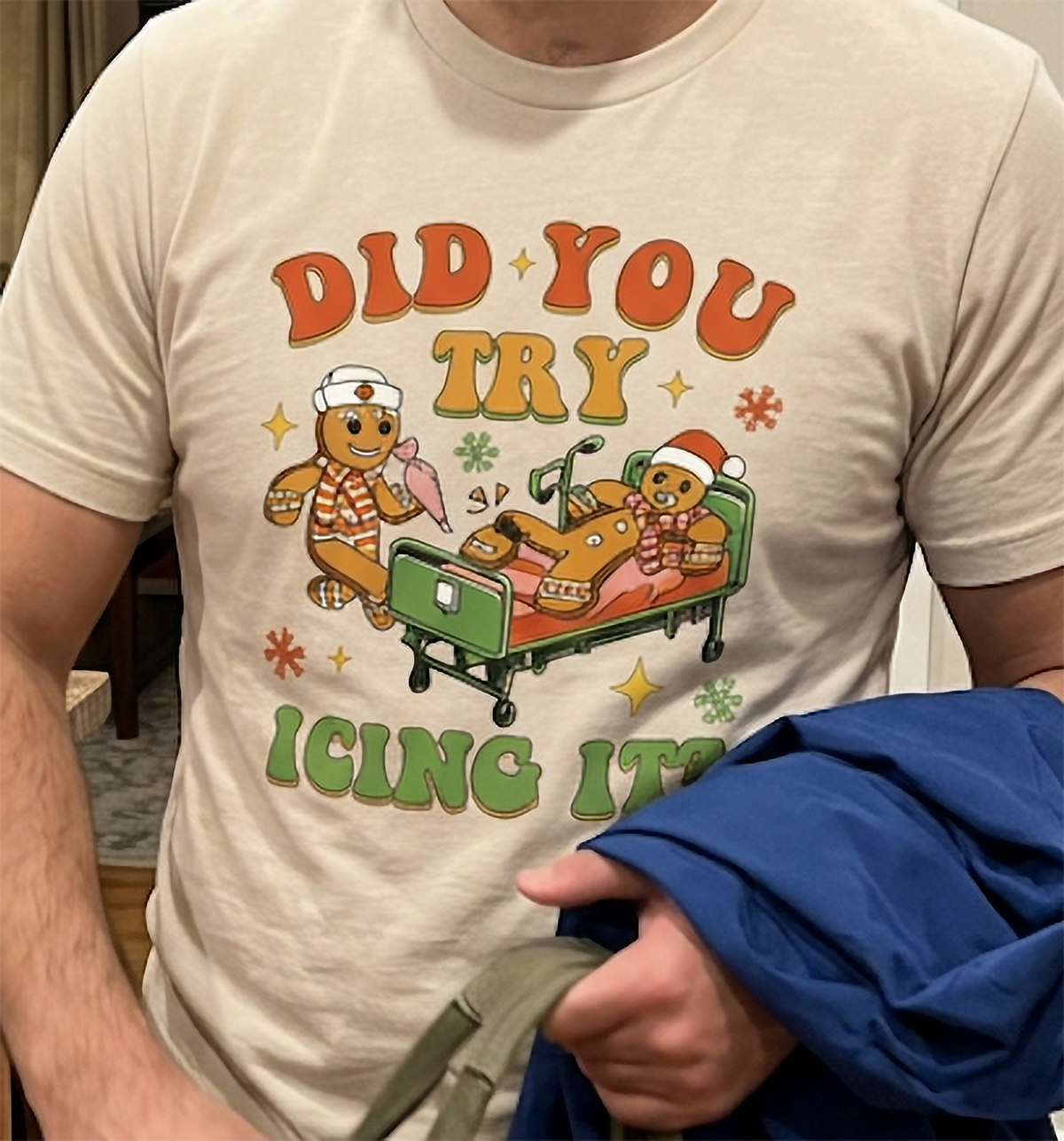 Close-up of gingerbread Christmas medical humor design printed on a sand-colored unisex t-shirt.