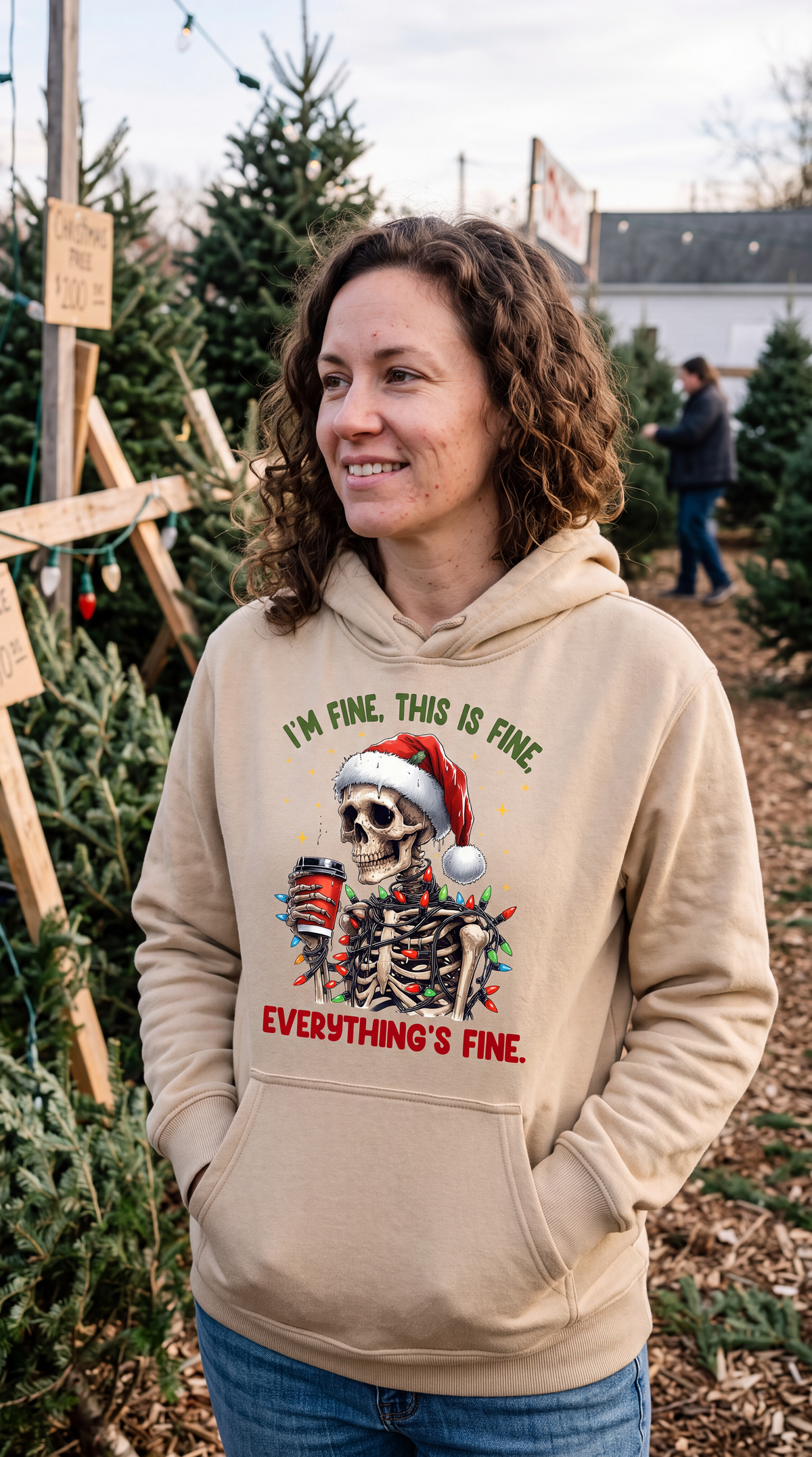 Woman wearing sand Christmas skeleton hoodie with I’m Fine Everything’s Fine design