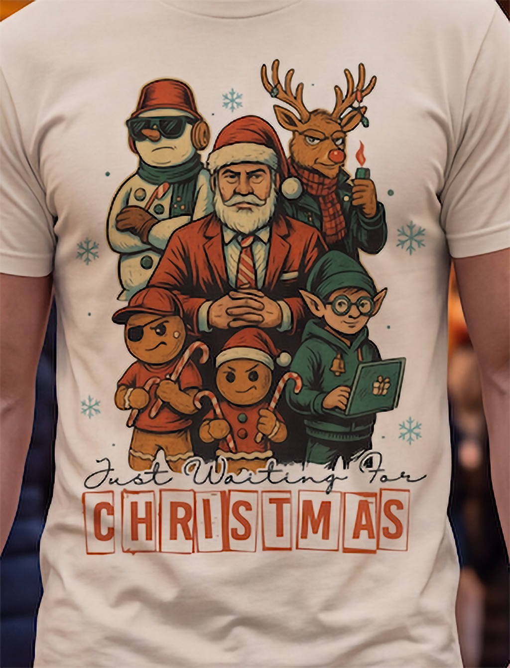 Sand Christmas graphic tee featuring a festive Santa, reindeer, elf, snowman and gingerbread character design.