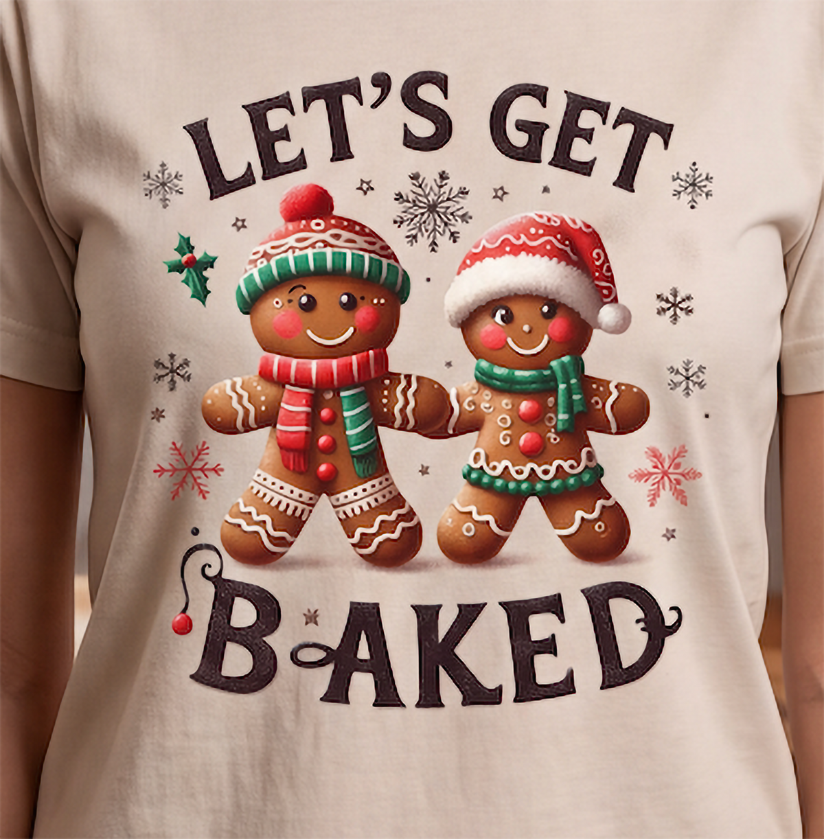 Close-up of Let’s Get Baked Christmas shirt design featuring a festive gingerbread couple with snowflakes and holly.