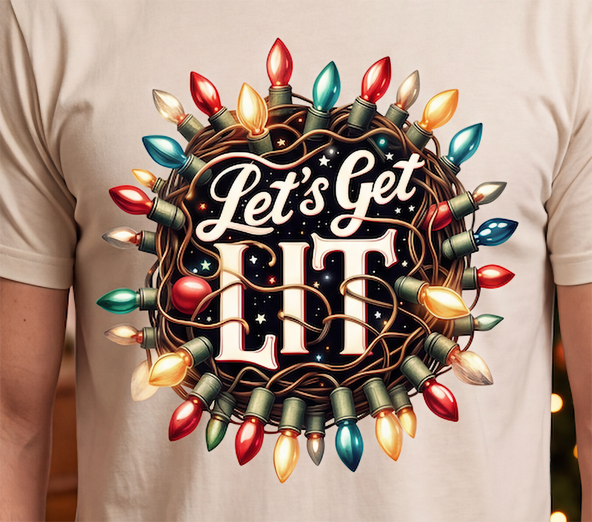Close-up of Let’s Get Lit colorful Christmas lights graphic printed on sand shirt