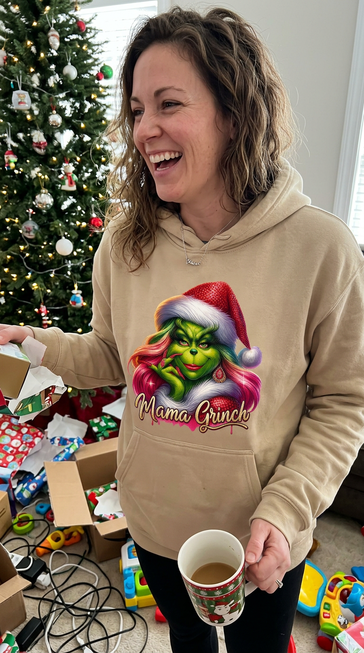 Woman wearing sand Mama Grinch hoodie for a festive holiday outfit