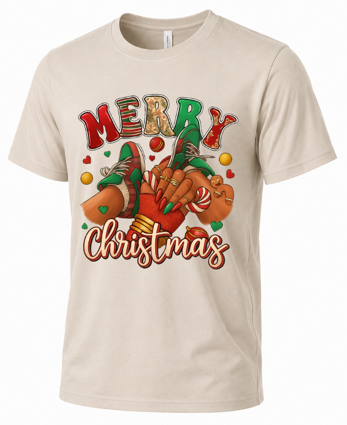 Sand Mockup: Sand Bella Canvas unisex Christmas t-shirt featuring Merry Christmas lettering, festive sneakers, and gingerbread decorations.