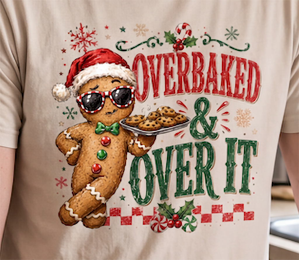 Close-up of Overbaked and Over It gingerbread Christmas design printed on sand colored tee.