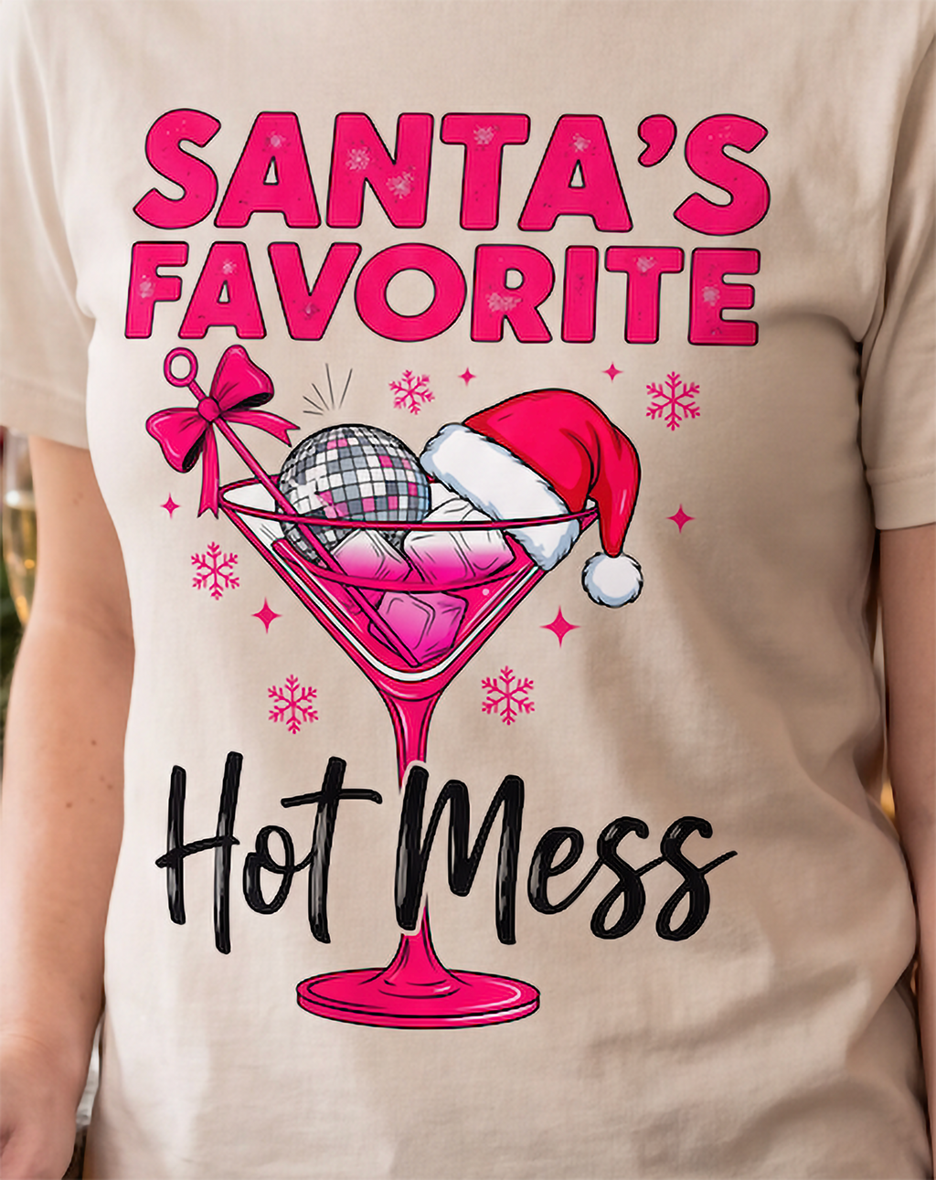 Close-up of Santa’s Favorite Hot Mess Christmas cocktail graphic on sand shirt