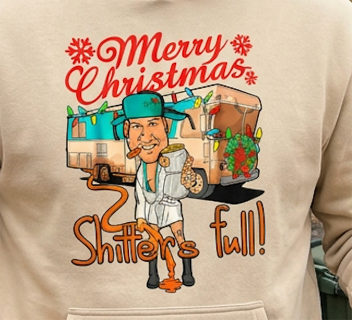 Close-up of Shitter’s Full Cousin Eddie Christmas graphic on sand hoodie