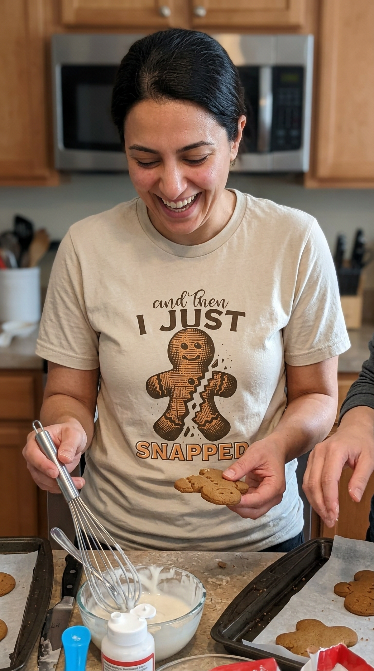 Sand Lifestyle: Woman wearing a sand-colored And Then I Just Snapped gingerbread Christmas t-shirt while baking in a kitchen.