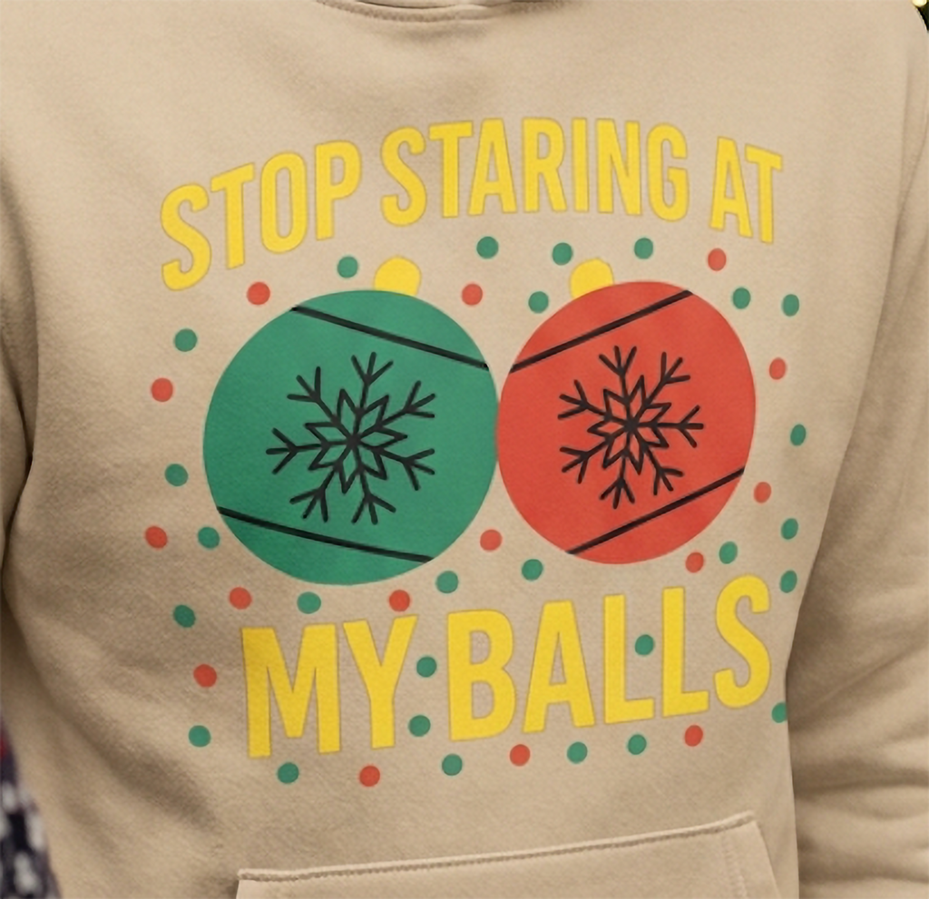 Close-up of Stop Staring at My Balls funny Christmas design on sand hoodie