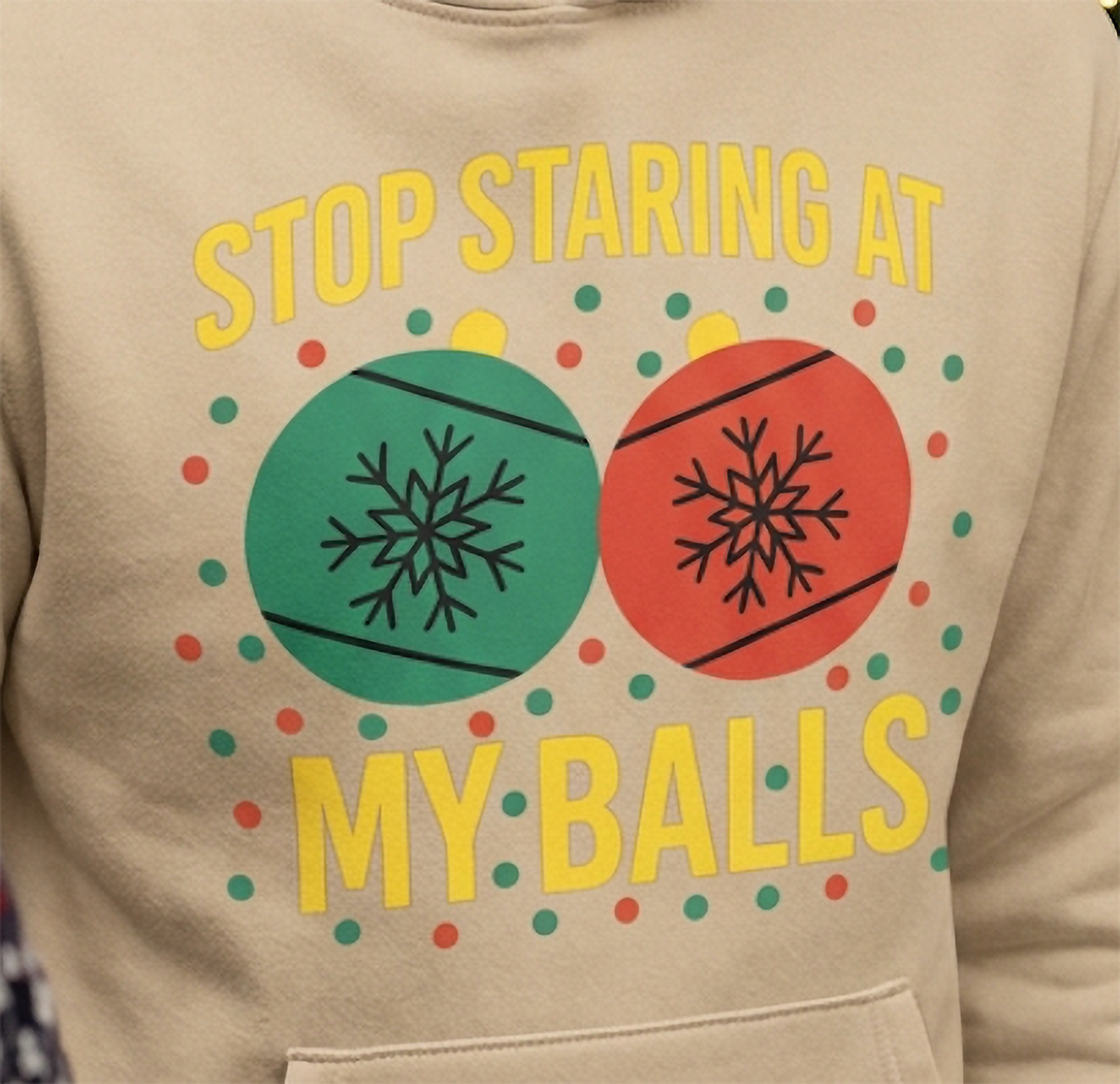 Close-up of Stop Staring at My Balls funny Christmas design on sand hoodie