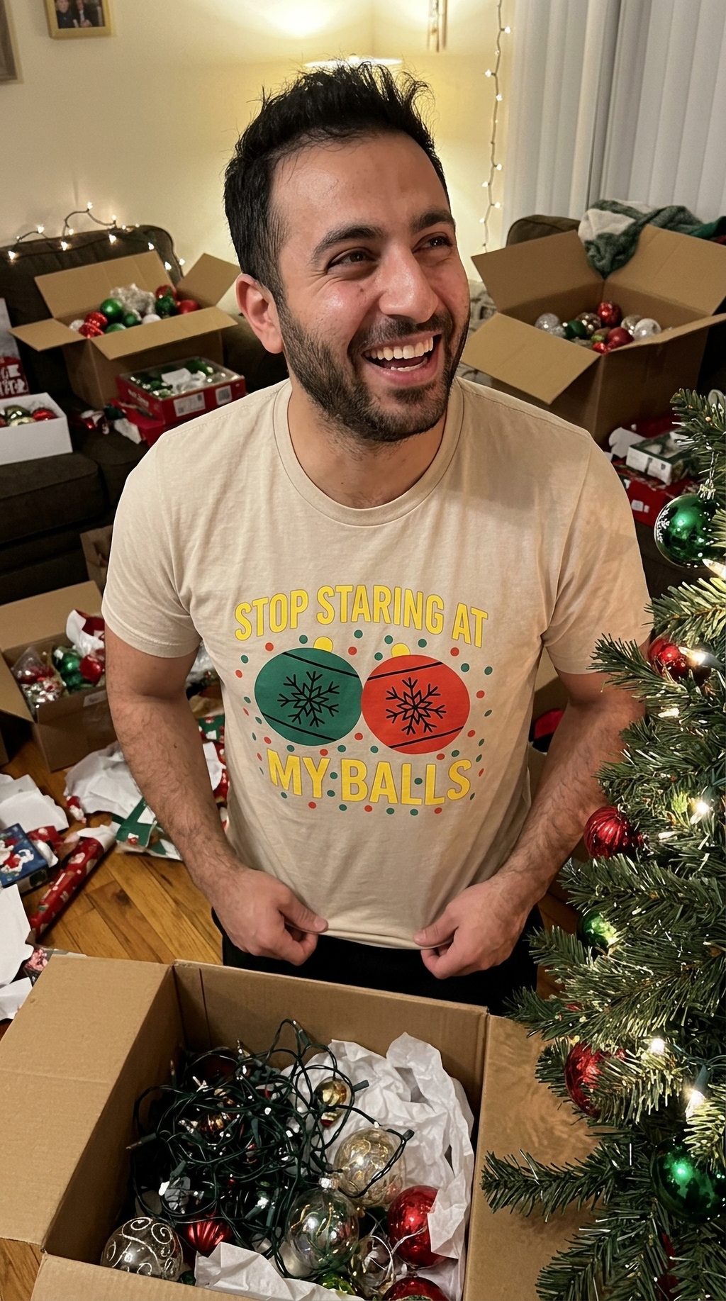Man wearing sand-colored funny Christmas t-shirt while decorating a Christmas tree for the holidays.