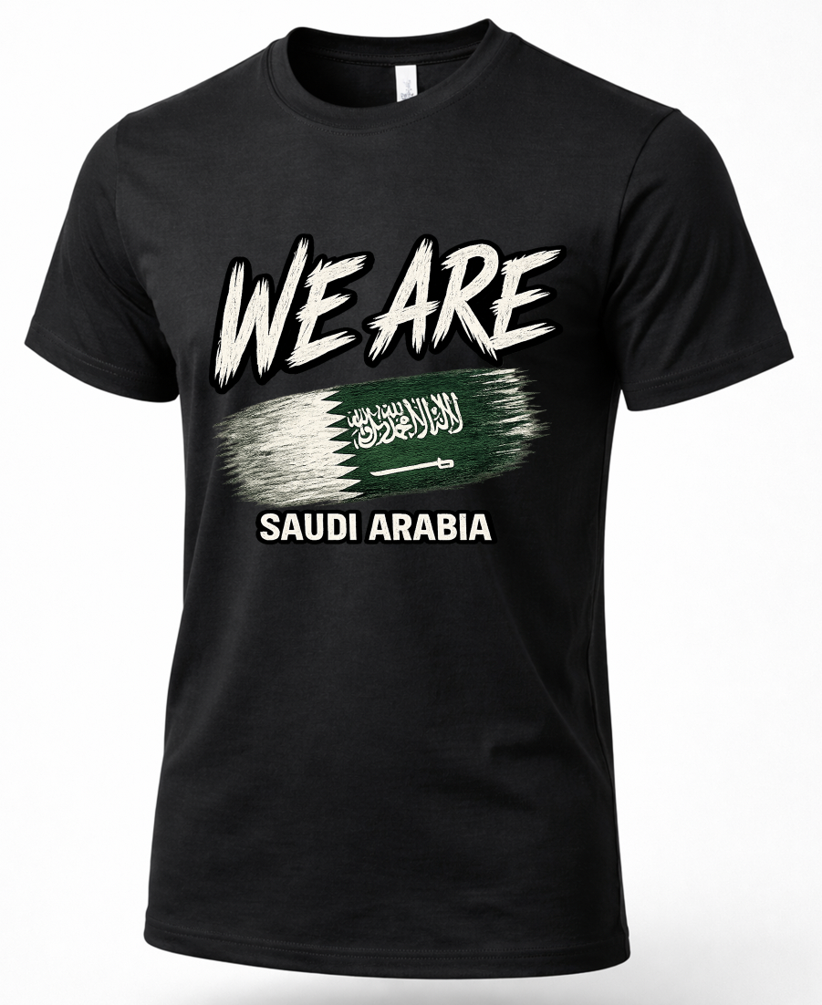 A black short-sleeve crewneck t-shirt featuring a graphic print on the front. The design displays the text 'WE ARE' in a distressed white brush font, a green and white Saudi Arabian flag brushstroke in the center, and 'SAUDI ARABIA' printed below in white.