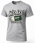 A heather gray short-sleeve t-shirt with a graphic print on the front. The design features the text 'WE ARE' in a bold, stylized white font with black outlines, above a green and white brushstroke design resembling the Saudi Arabian flag, with 'SAUDI ARABIA' printed below in white.