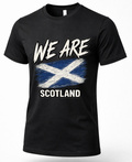 A black short-sleeve crewneck t-shirt featuring a distressed graphic print of the Scottish flag with the text 'WE ARE SCOTLAND' in white.
